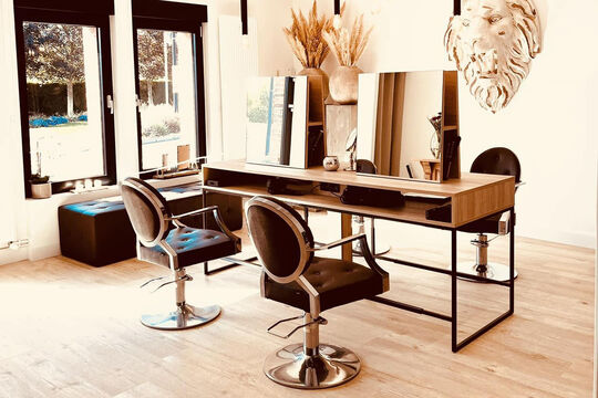 Photo de l'intérieur du salon de coiffure. On voit un ilot central avec deux fauteuils