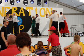 Photo d'une prestation de danse sur un podium lors d'une fête du village