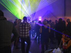 Photo d'une soirée avec des personnes qui dansent et des lumières d'ambiance.
