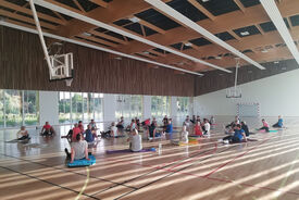 Photo d'un groupe de personnes dans la salle de sport, assise en train de faire des étirements