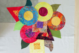 Photo d'un travail en patchwork, très coloré, avec des formes géométriques.